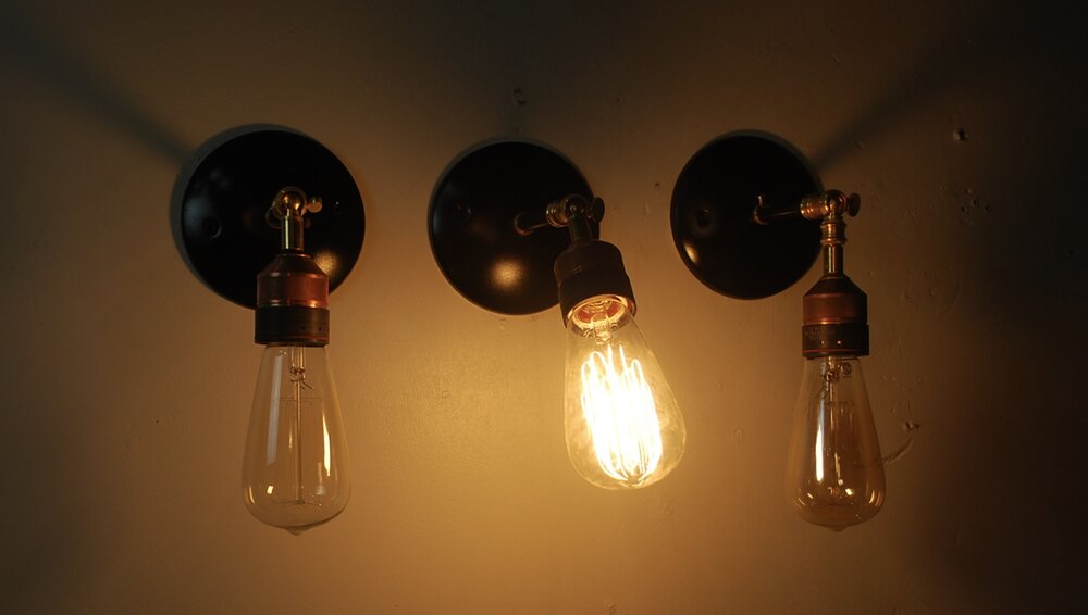 Set of three articulating copper / brass wall sconces | Scott Landon Antiques and Interiors.