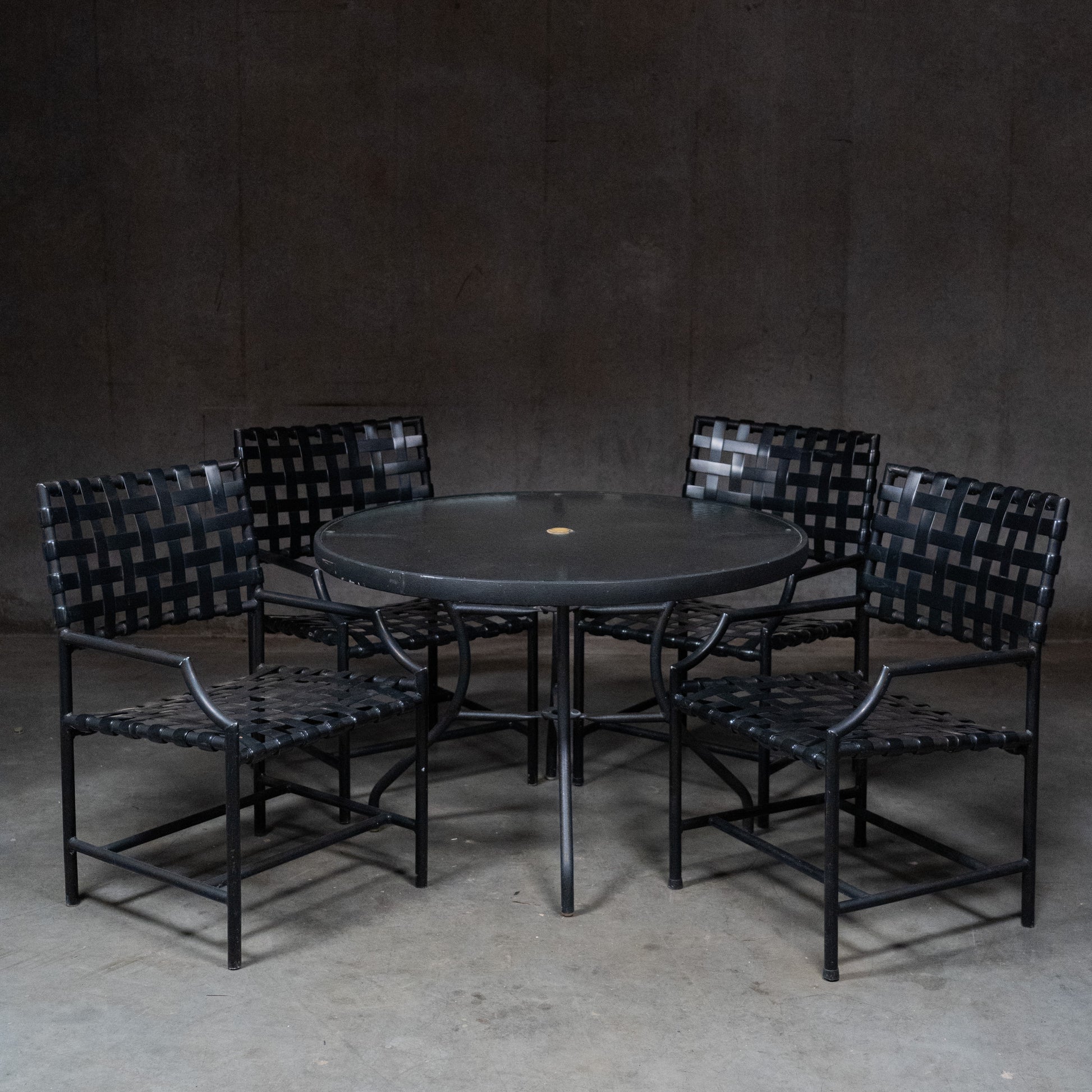  Vintage Tropitone black patio dining set with round table and four woven strap armchairs | Scott Landon Antiques and Interiors.