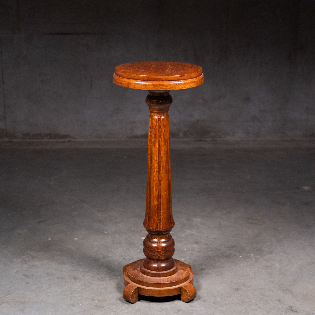 Antique c.1900 quarter-sawn oak pedestal plant stand with figured tapered column, circular top and raised four-foot base | Scott Landon Antiques and Interiors.
