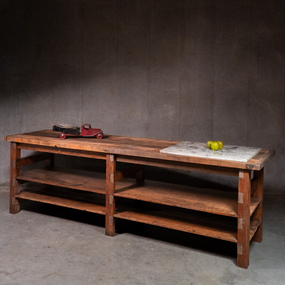 Large vintage wooden grocer’s worktable from Tosi Italian Food Imports in Vancouver, with plank top and two lower shelves. | Scott Landon Antiques and Interiors.