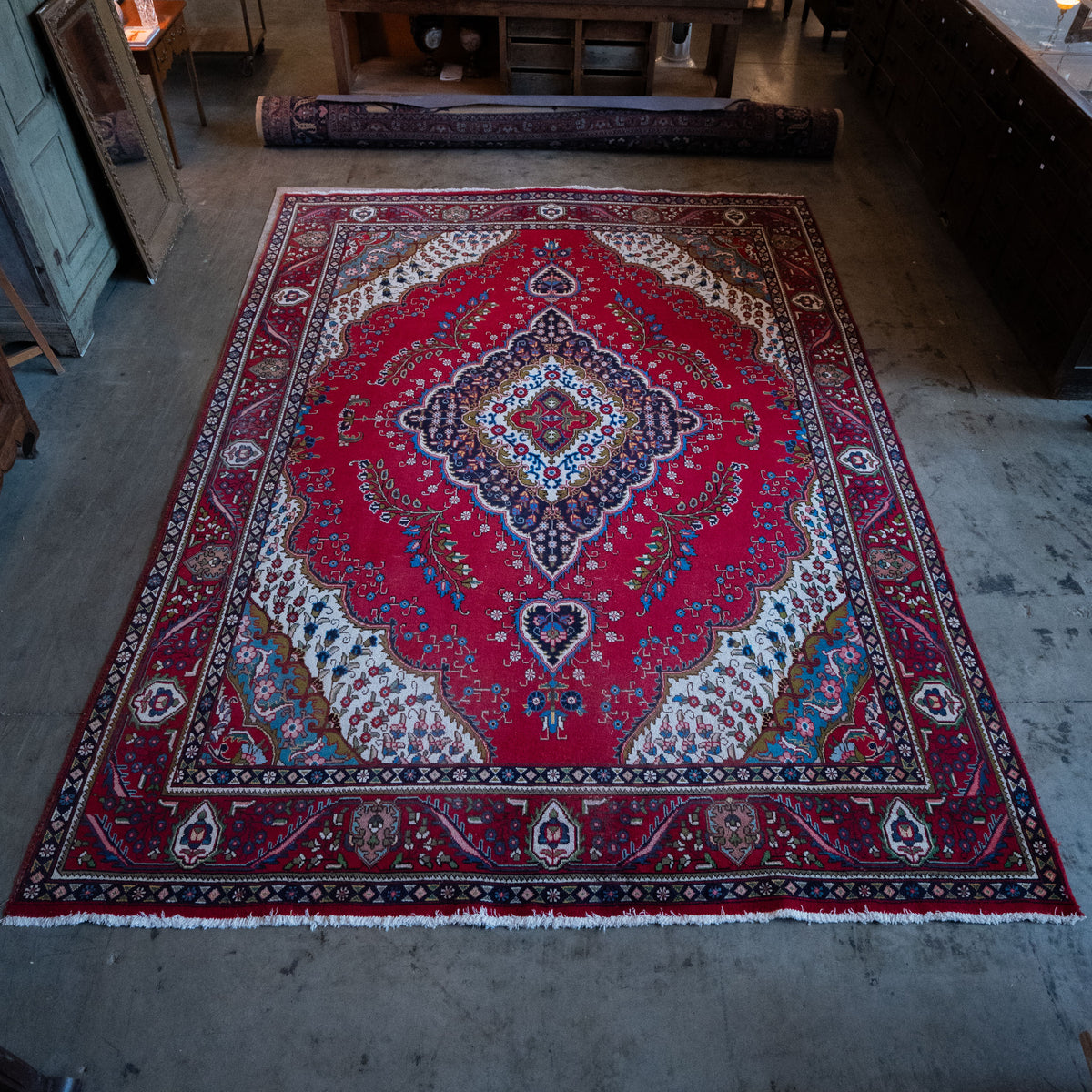 Vintage hand-knotted red area rug with navy floral medallion, ivory corner panels, and patterned border. | Scott Landon Antiques and Interiors.