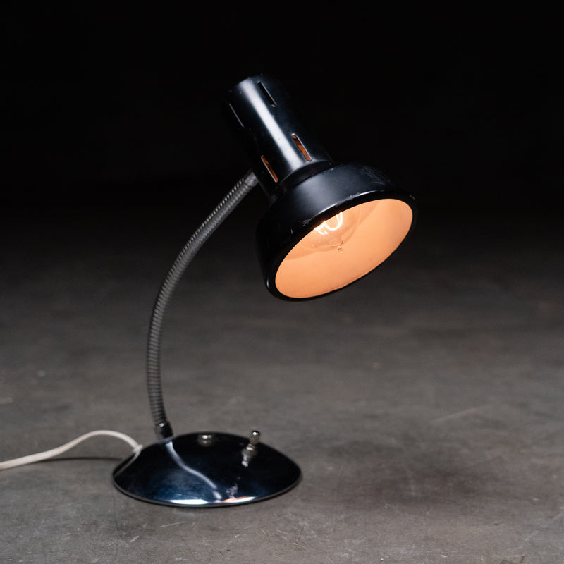 Vintage mid-century modern adjustable gooseneck task lamp with black metal shade and chrome flexible arm, circa 1960s.