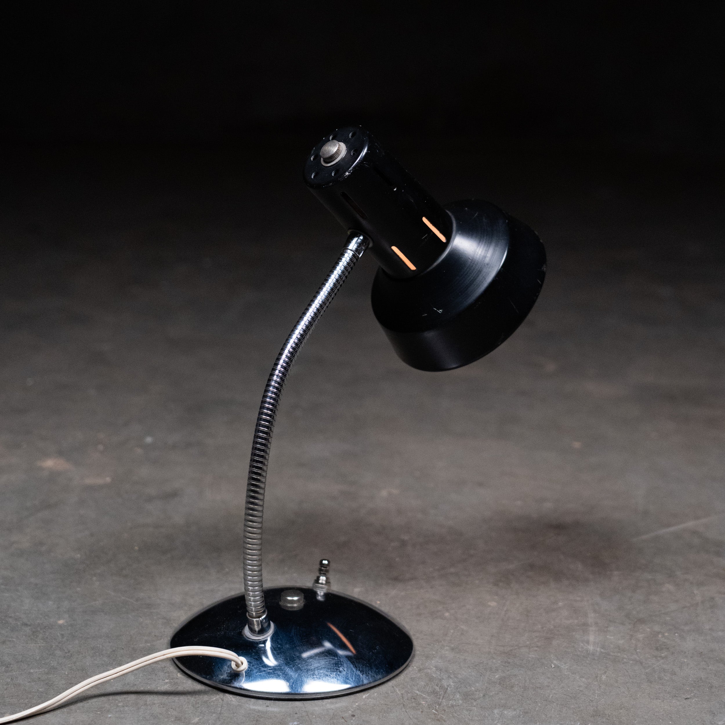 Black adjustable desk lamp on a dark surface