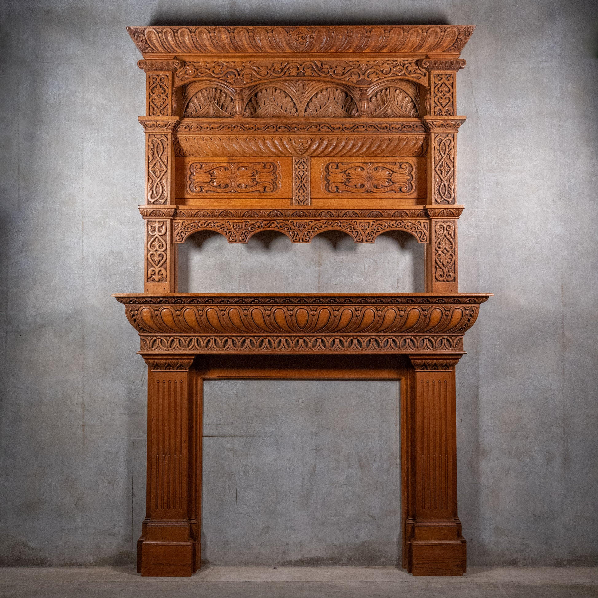 Monumental Victorian Renaissance Revival oak fireplace mantel dated 1893 with hand-carved Gothic arches and architectural overmantel
