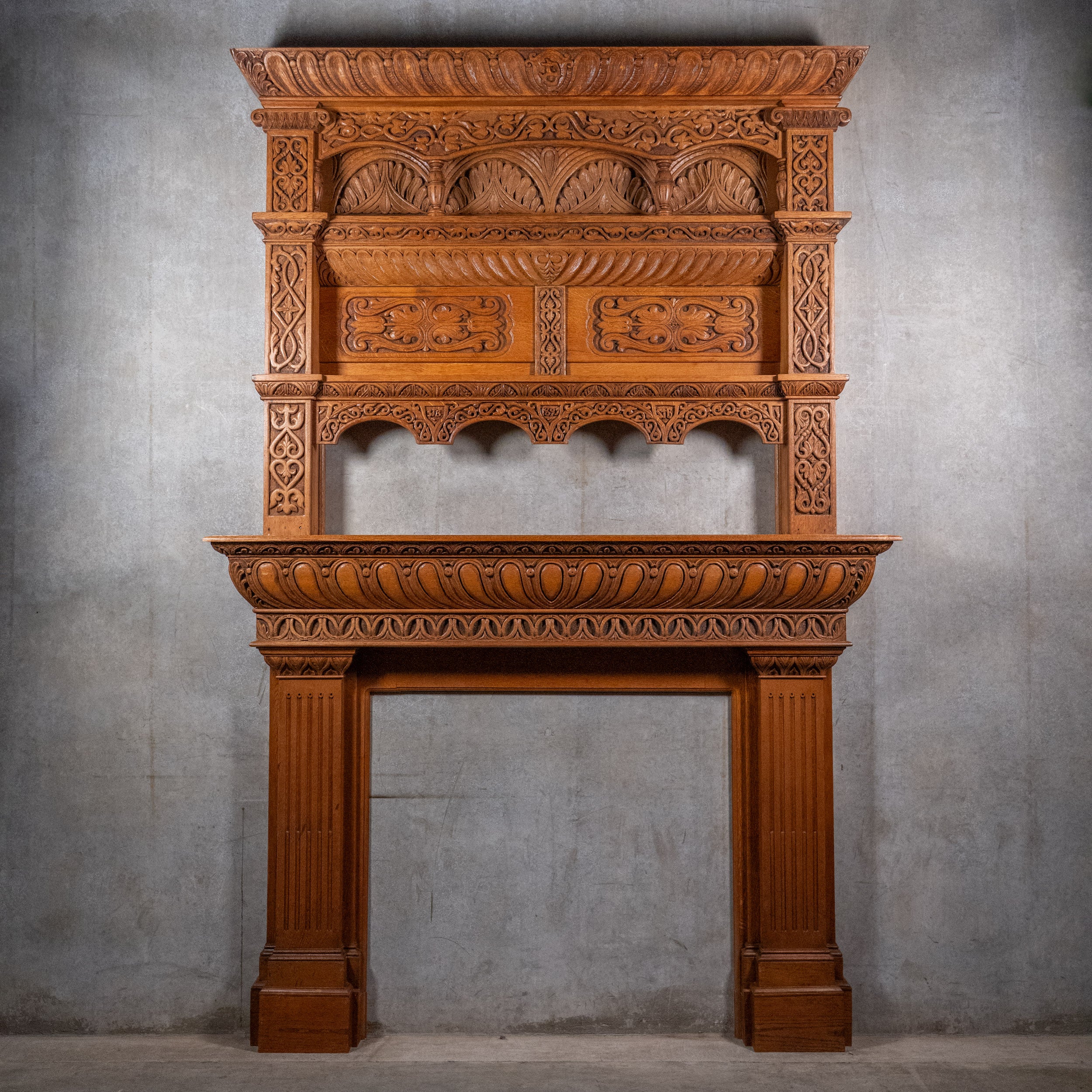Monumental Victorian Renaissance Revival oak fireplace mantel dated 1893 with hand-carved Gothic arches and architectural overmantel
