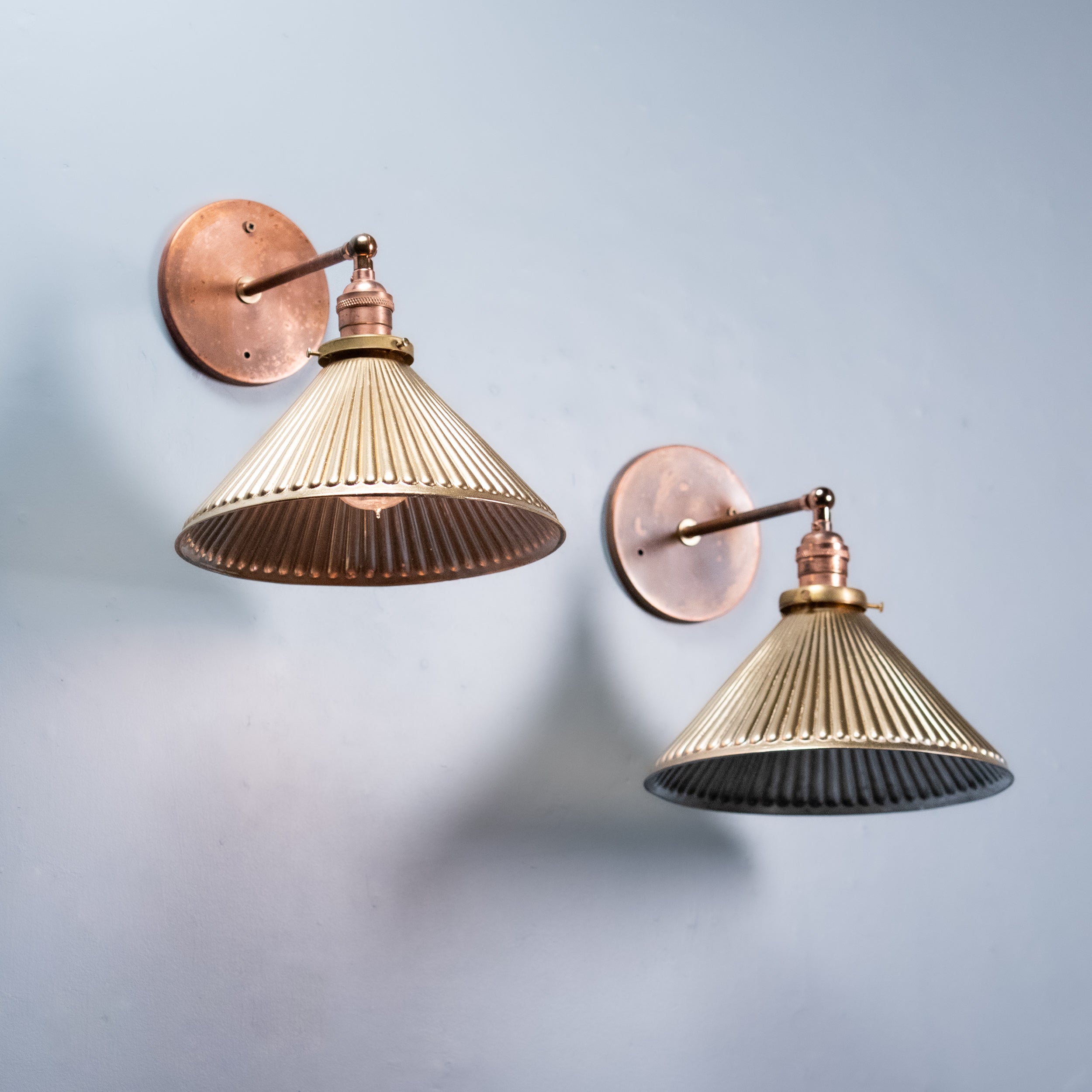 Pair of Art Deco mercury glass wall sconces with ribbed silvered glass shades and aged copper hardware, circa 1930