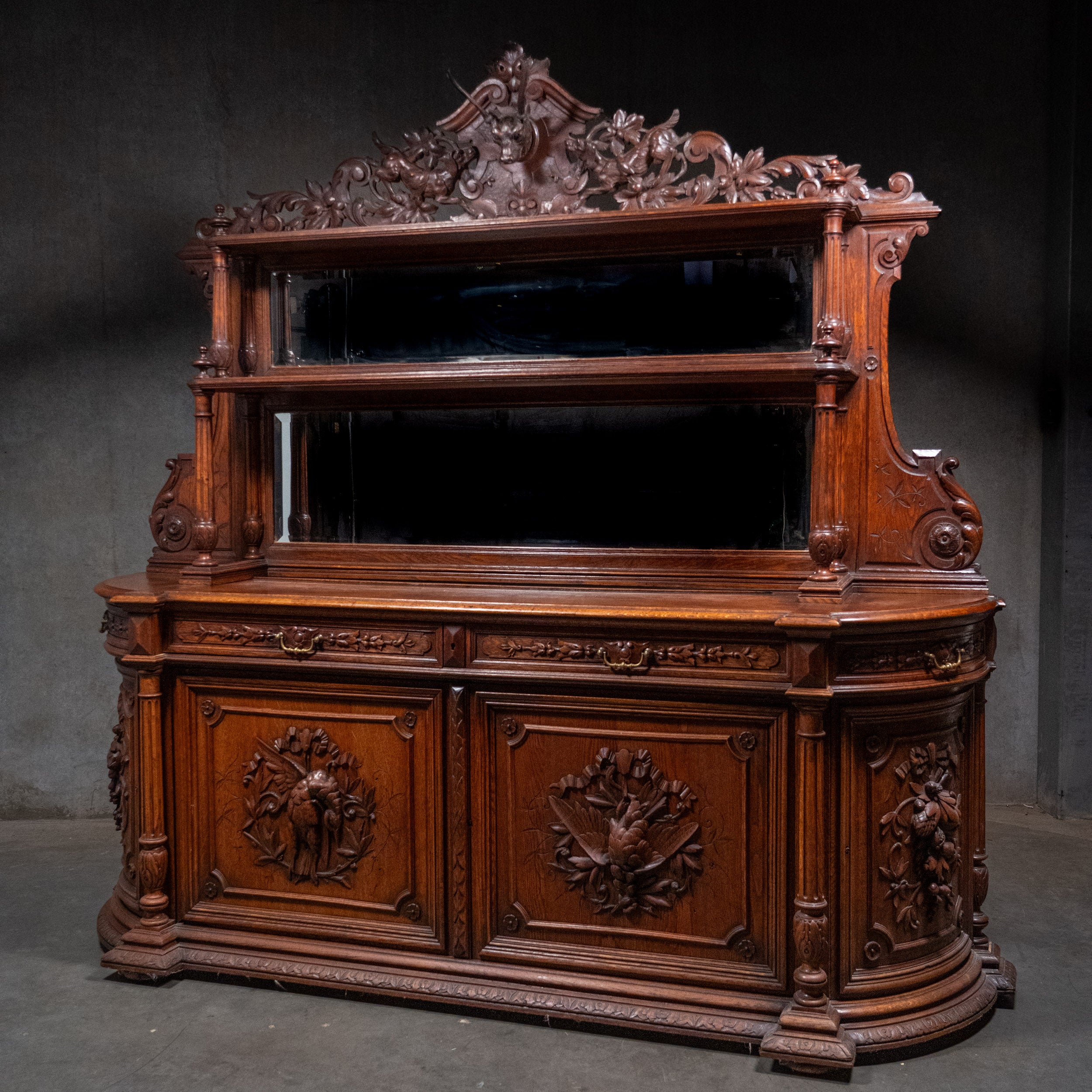 Monumental French Henri II Revival carved oak hunting buffet cabinet with stag crest and game bird carvings circa 1890.