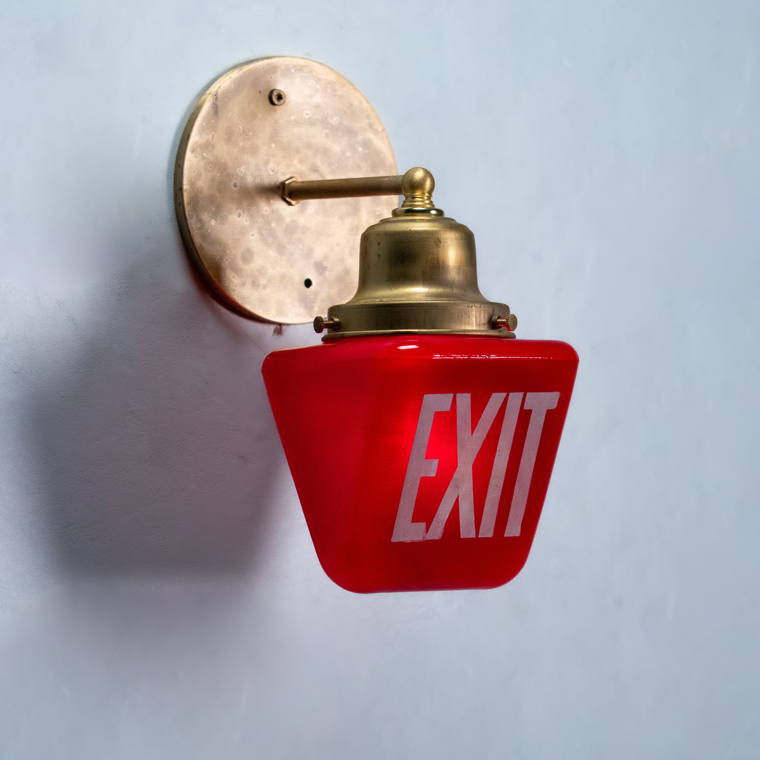 Vintage red EXIT glass wall sconce with handcrafted solid brass mount made from reclaimed theatre architectural salvage.