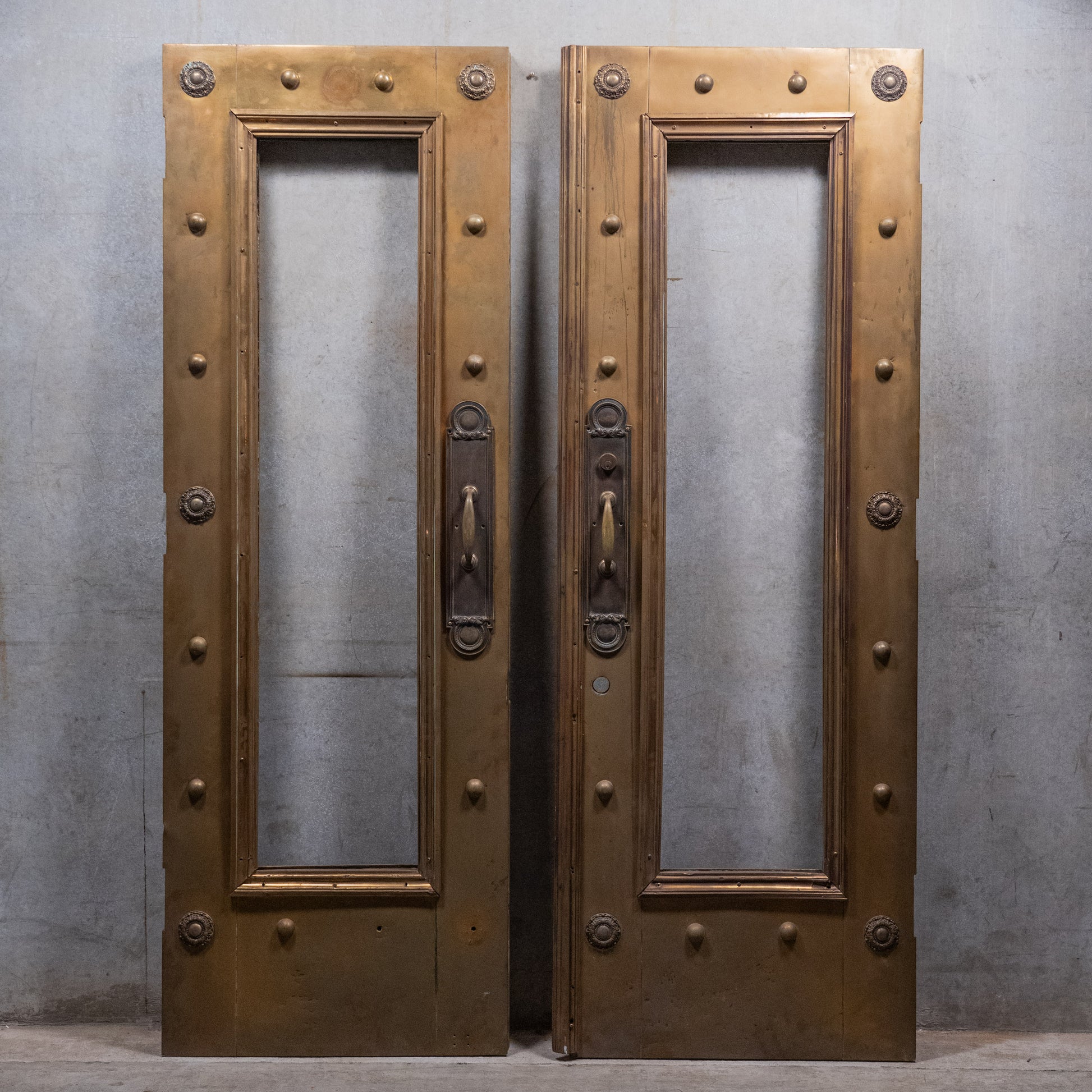 Pair of monumental circa 1910 brass-clad Beaux-Arts entrance doors with original bronze architectural hardware