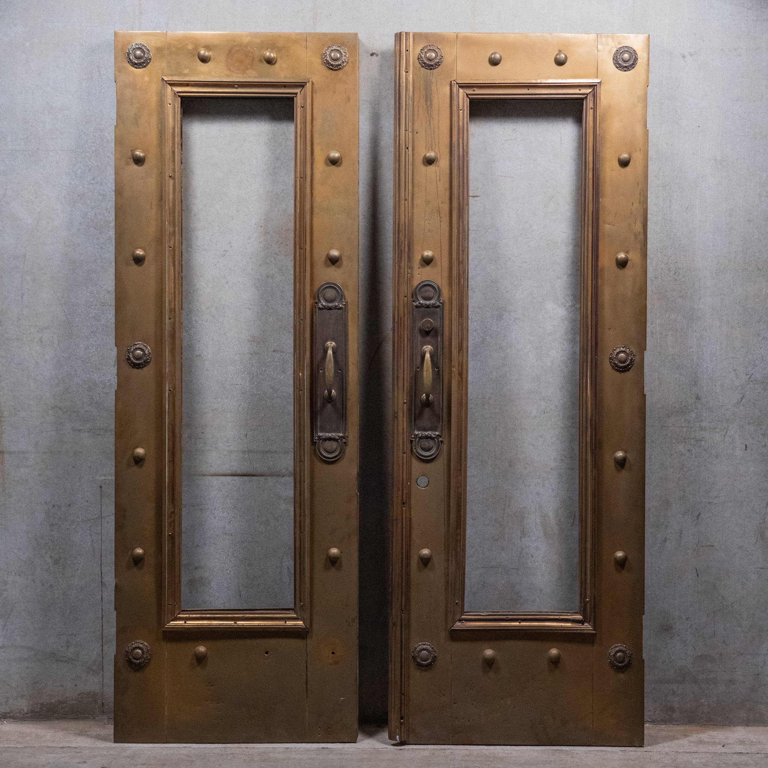 Pair of monumental circa 1910 brass-clad Beaux-Arts entrance doors with original bronze architectural hardware