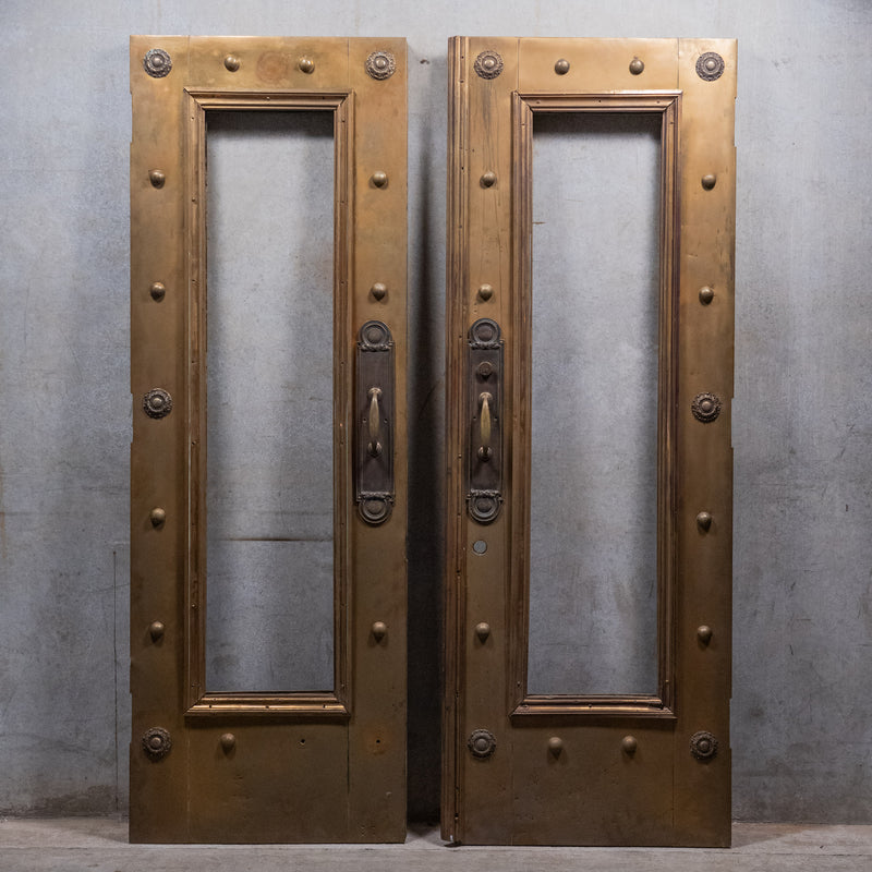 Pair of monumental circa 1910 brass-clad Beaux-Arts entrance doors with original bronze architectural hardware
