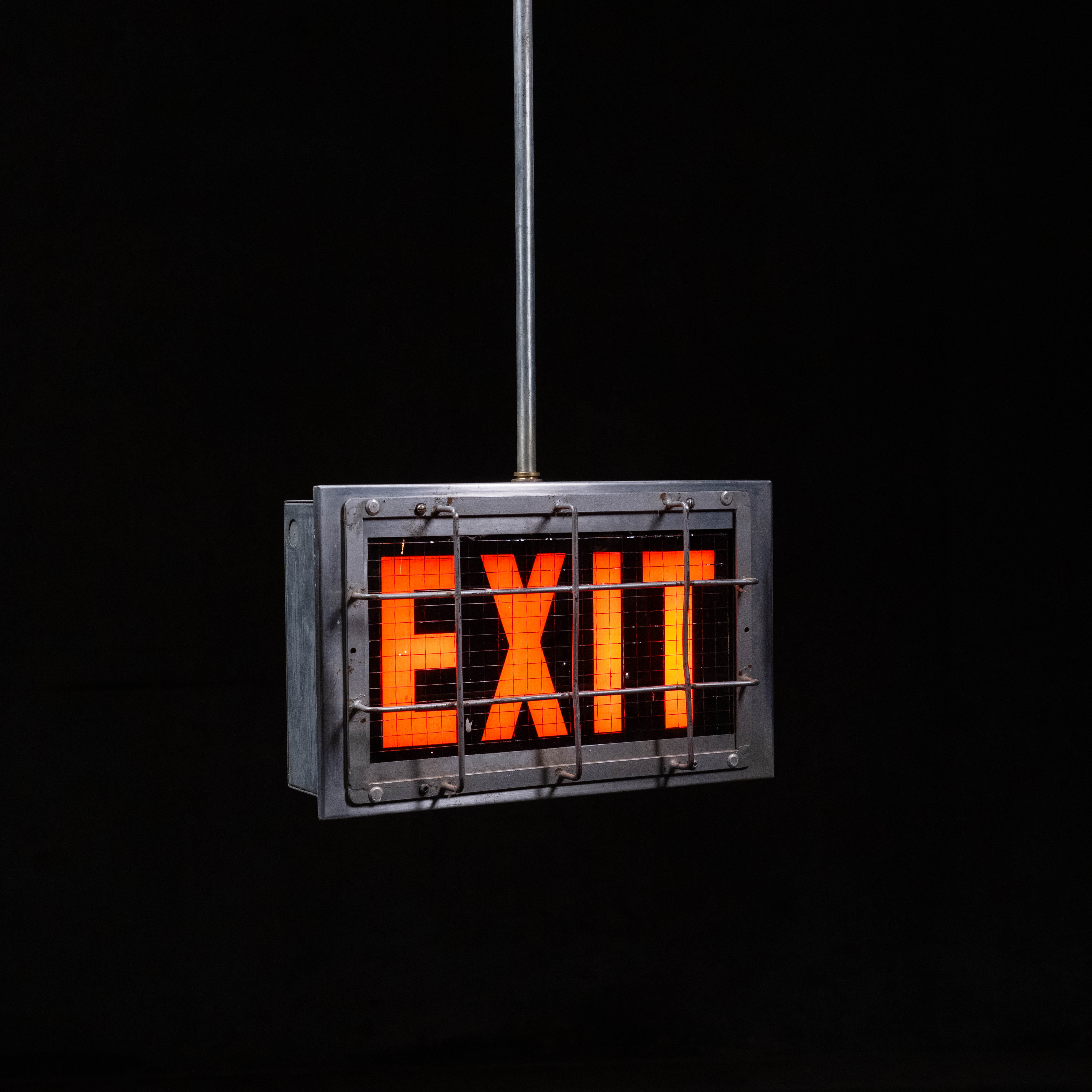 1940 glass exit sign with cage protector