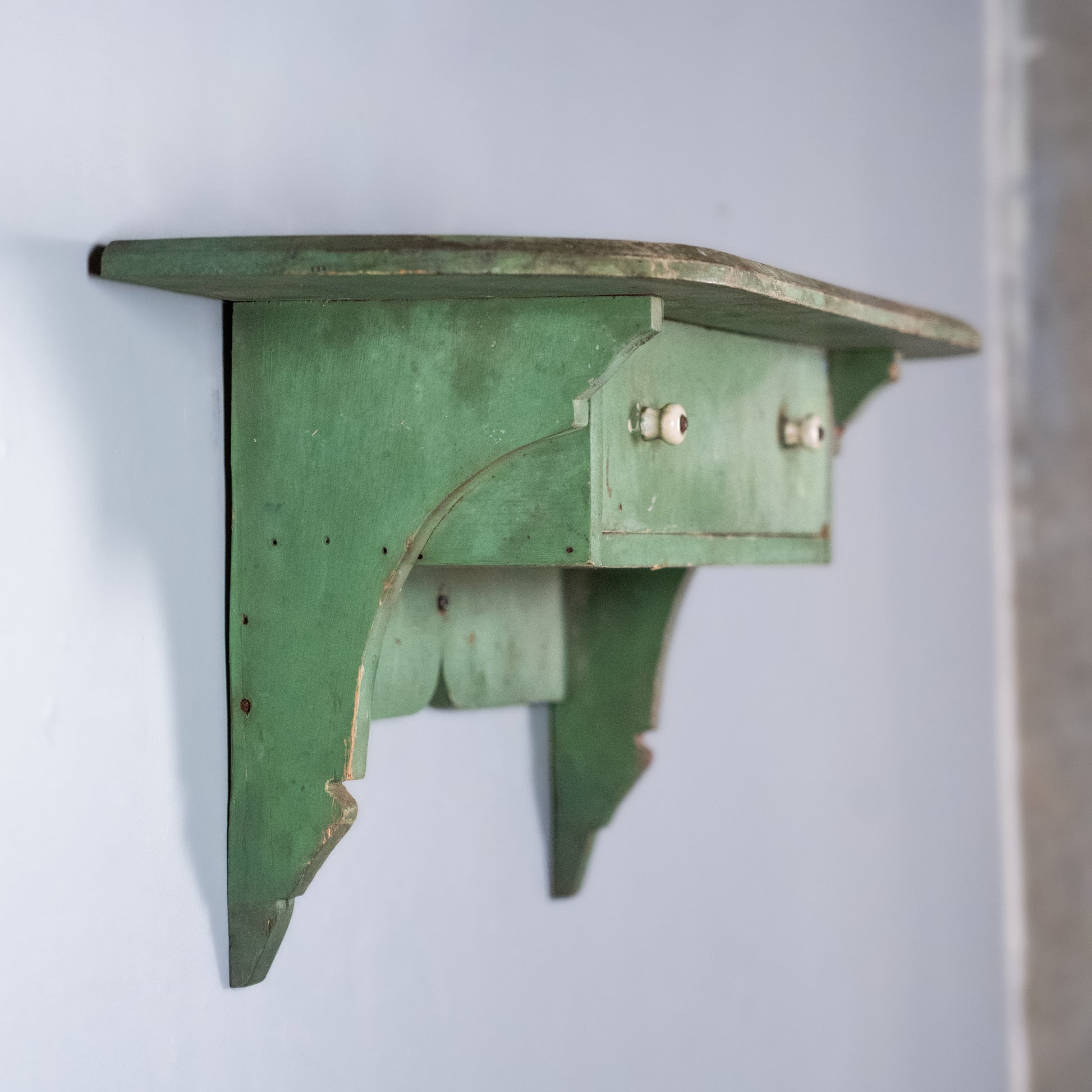 Antique Quebec pine wall shelf with drawer and original worn green paint