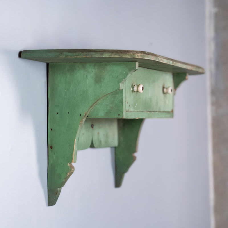 Antique Quebec pine wall shelf with drawer and original worn green paint