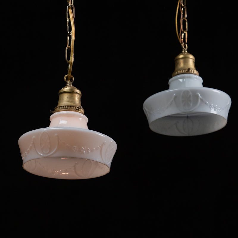 Pair of antique embossed opal glass pendant lights with original brass galleries and chain.
