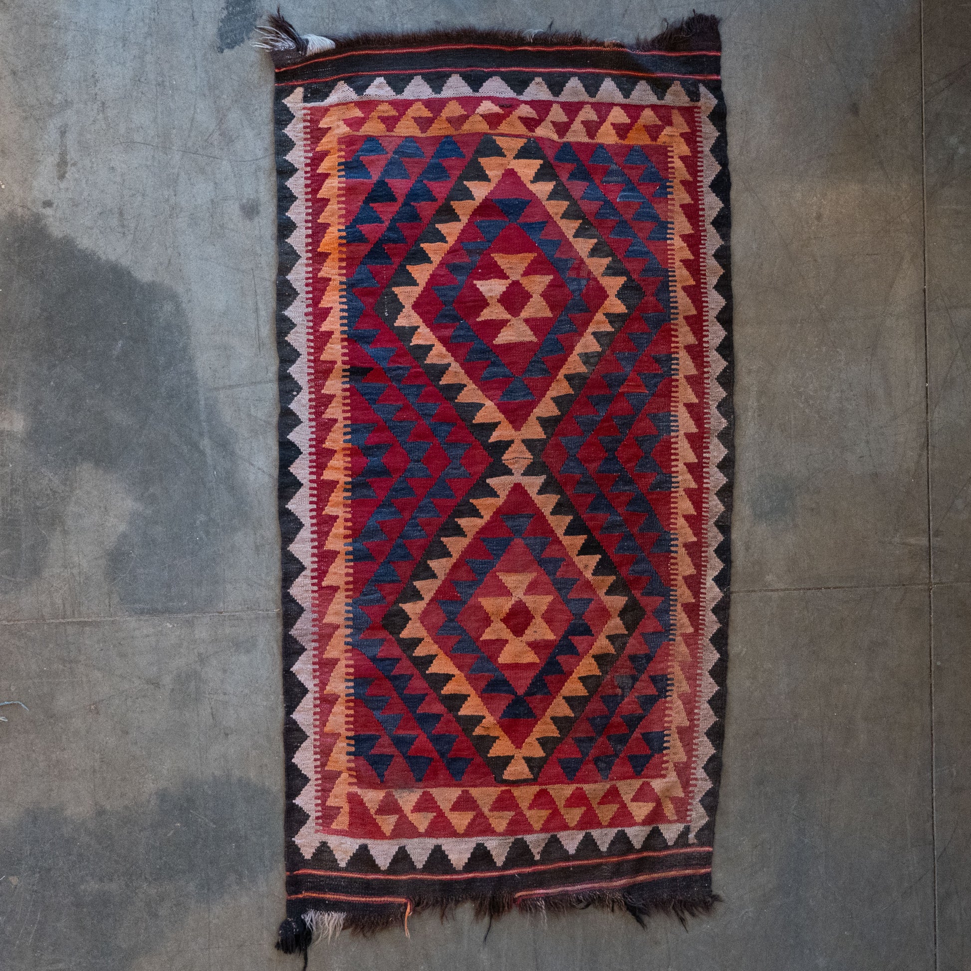 Vintage handwoven Afghan 3 x 5 tribal kilim rug with bold geometric diamond medallions in rich red, blue, and camel wool/Scott Landon Antiques and Interiors.