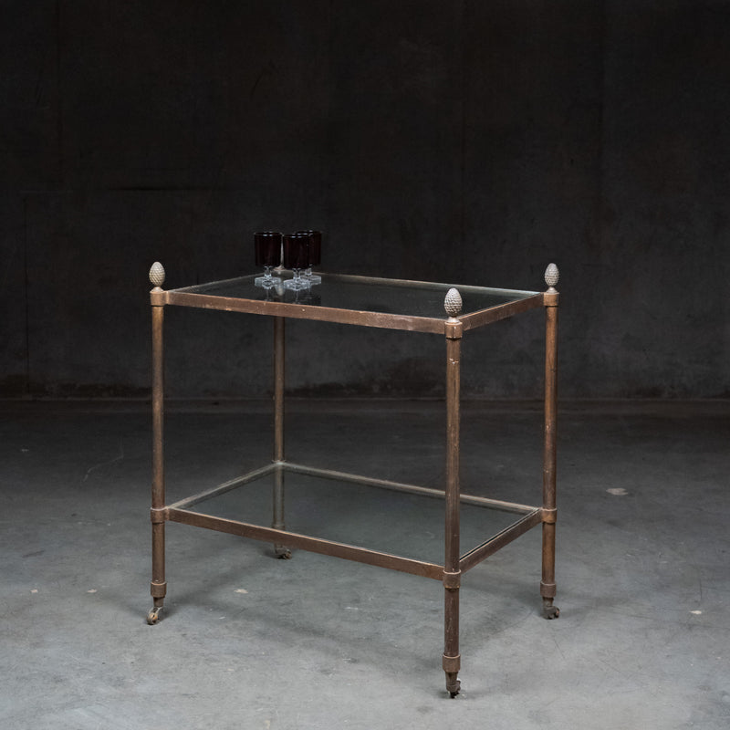 Vintage brass and glass bar cart with pinecone finials and two glass shelves in the Maison Jansen style.