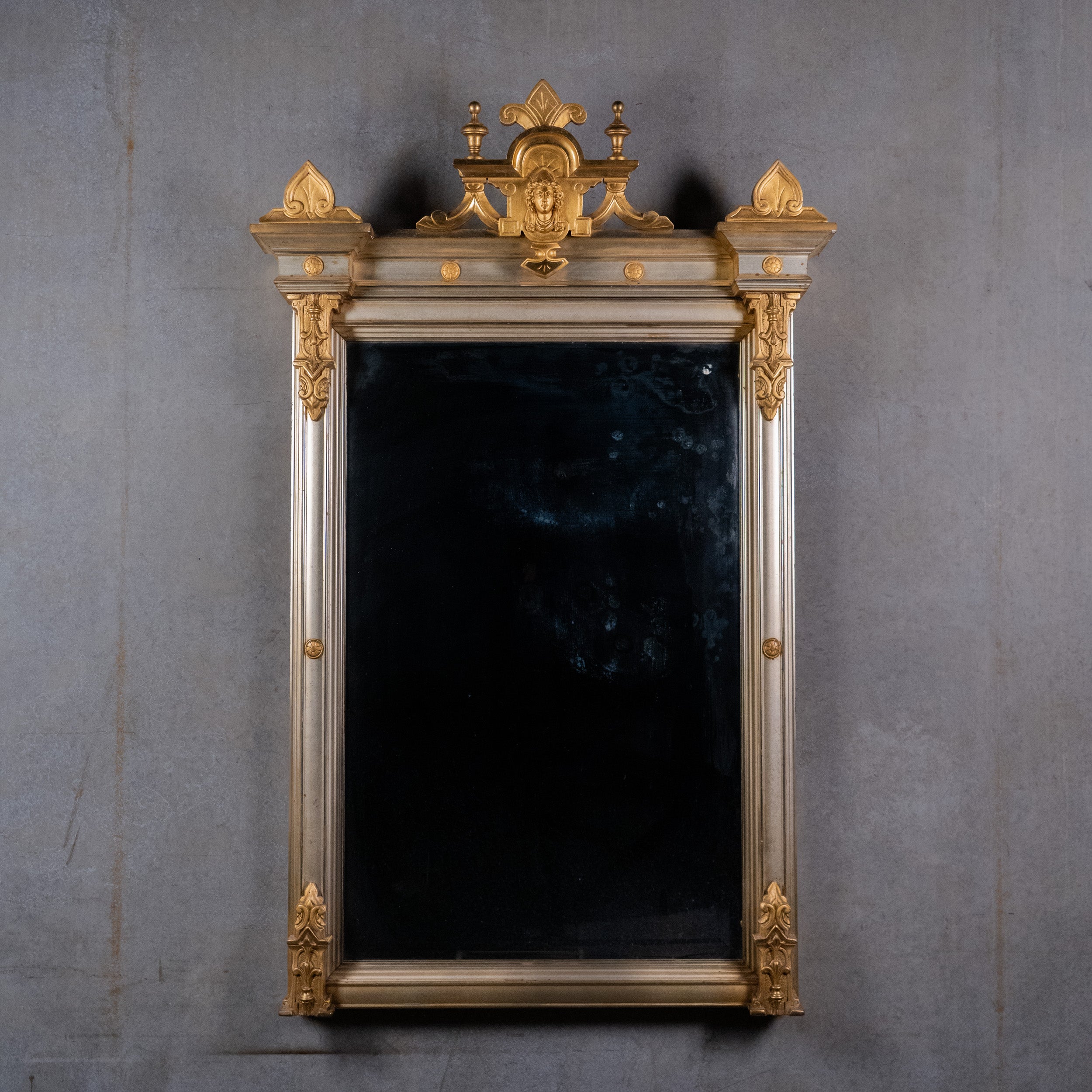 Antique Victorian gilt and silvered architectural wall mirror with classical female crest and fleur-de-lis ornament.