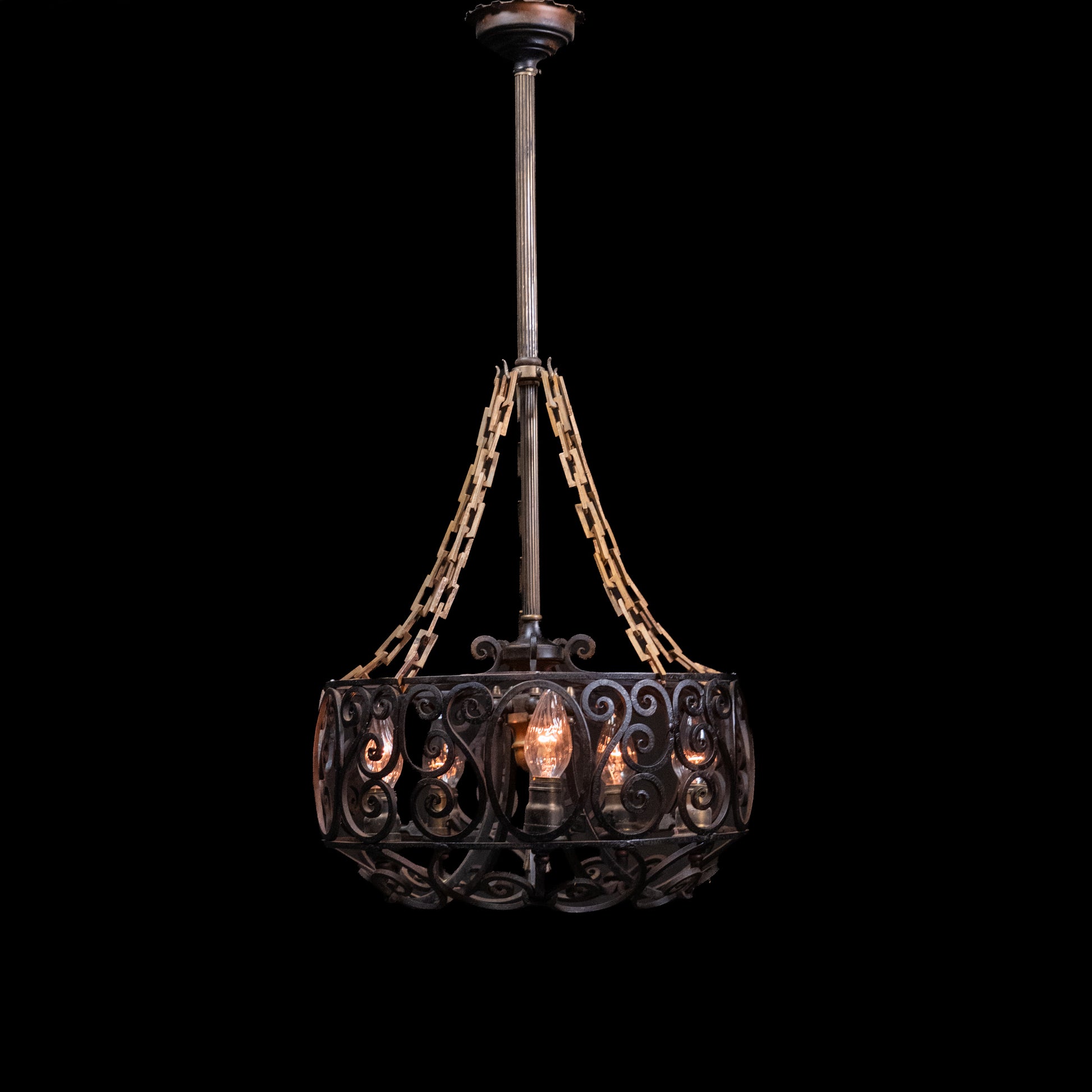 Antique Spanish Revival hand-forged wrought iron six-light chandelier with decorative scrollwork and original forged chain suspension. | Scott Landon Antiques and Interiors.