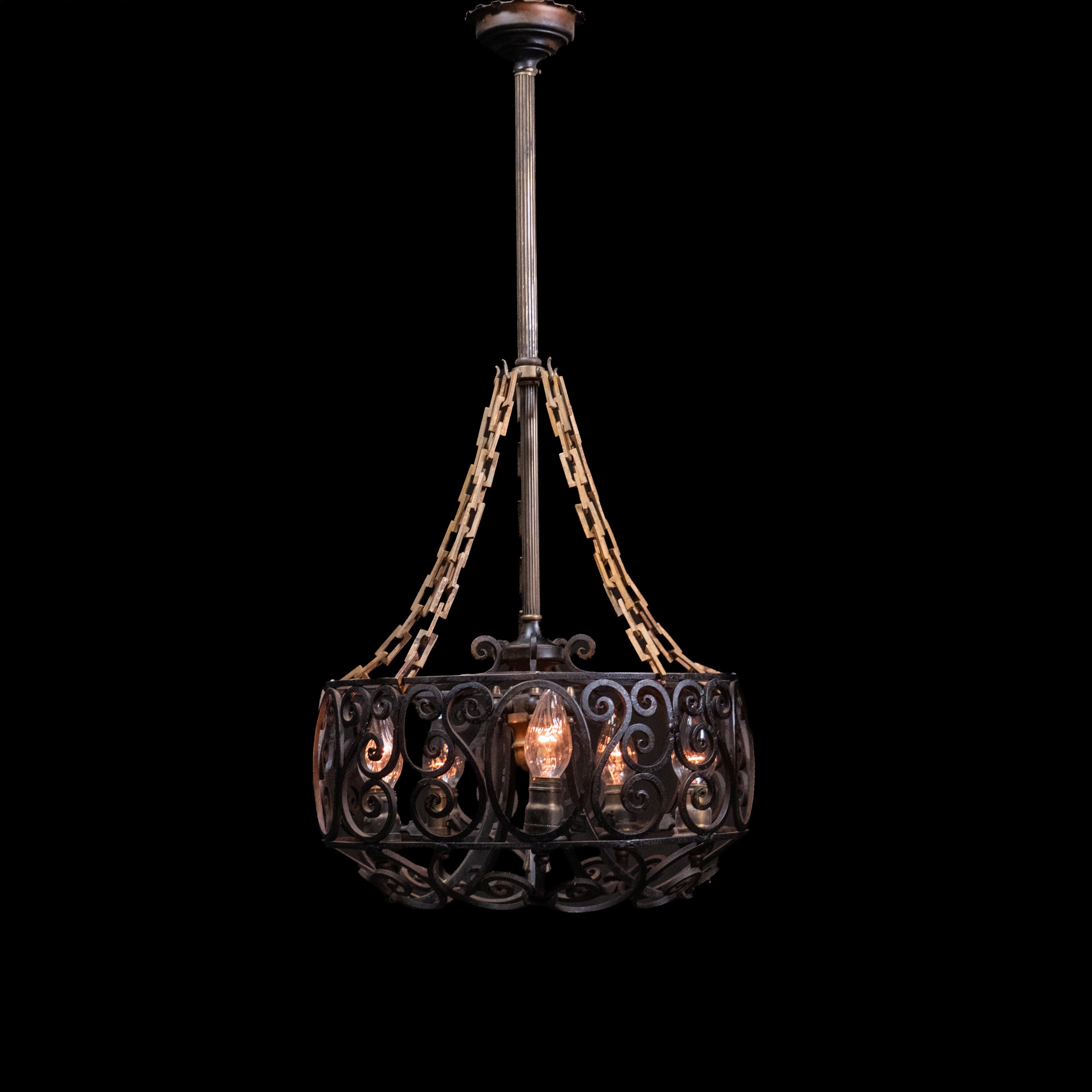 Antique Spanish Revival hand-forged wrought iron six-light chandelier with decorative scrollwork and original forged chain suspension. | Scott Landon Antiques and Interiors.