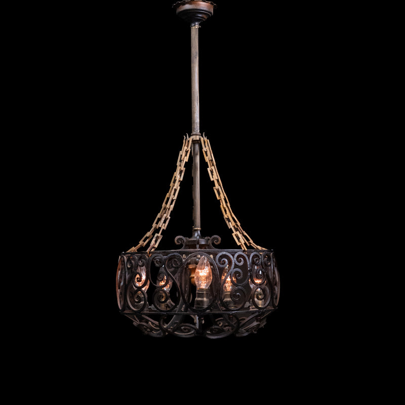Antique Spanish Revival hand-forged wrought iron six-light chandelier with decorative scrollwork and original forged chain suspension. | Scott Landon Antiques and Interiors.