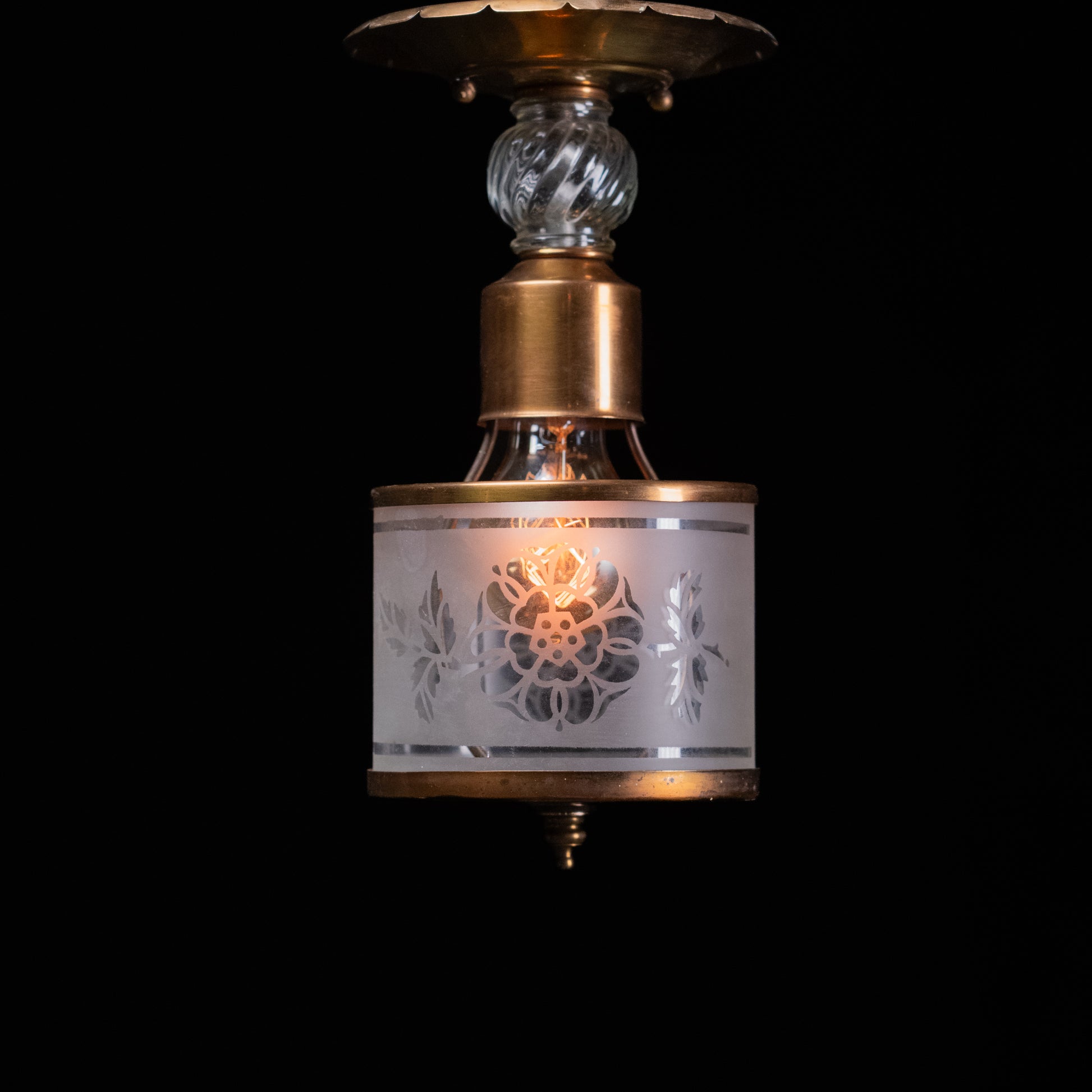 Antique brass pendant light with frosted acid-etched floral glass cylinder shade and decorative clear glass spacer.