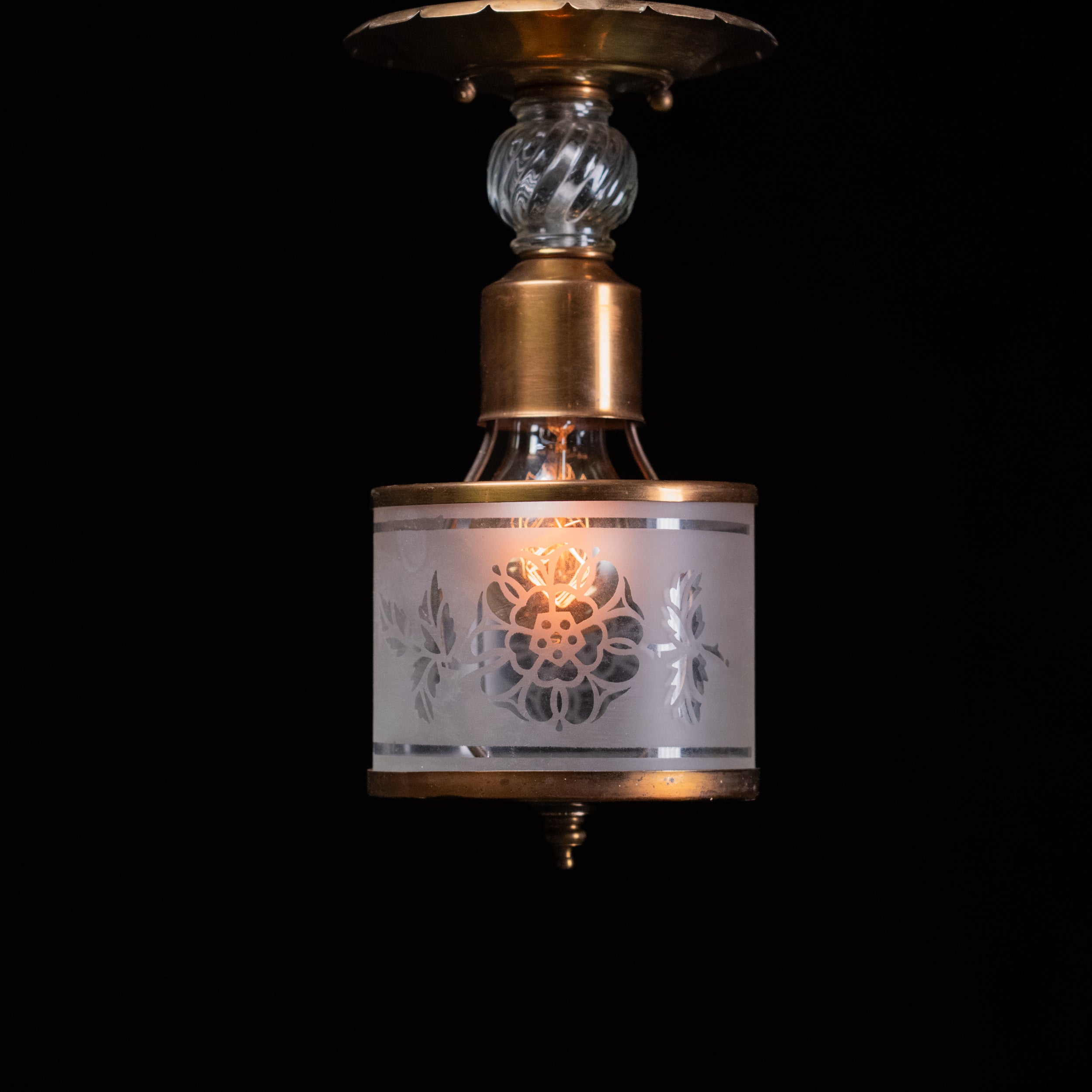 Antique brass pendant light with frosted acid-etched floral glass cylinder shade and decorative clear glass spacer.
