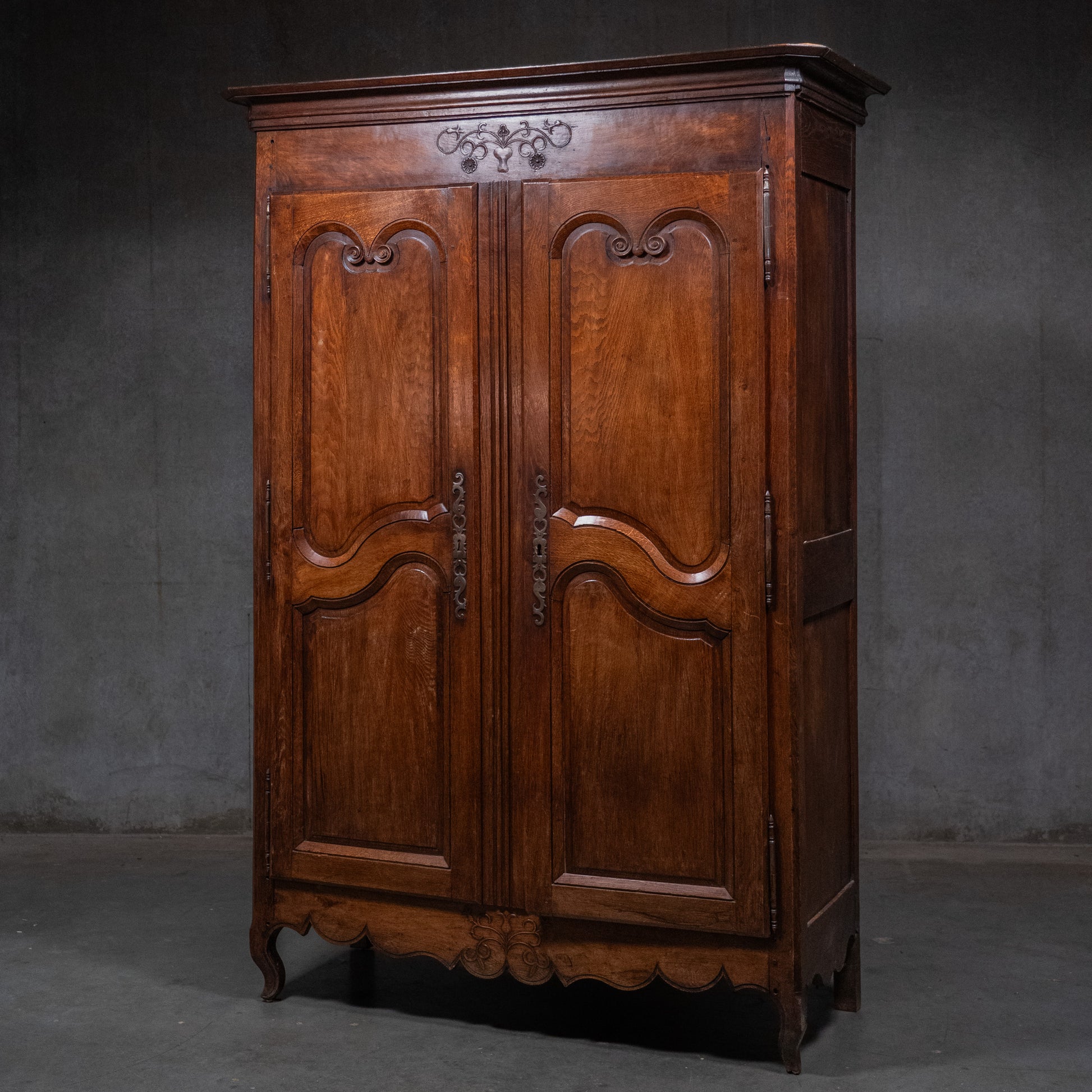 Early 19th-century French provincial solid oak armoire with carved panel doors, pegged construction, and original iron hardware. | Scott Landon Antiques and Interiors.
