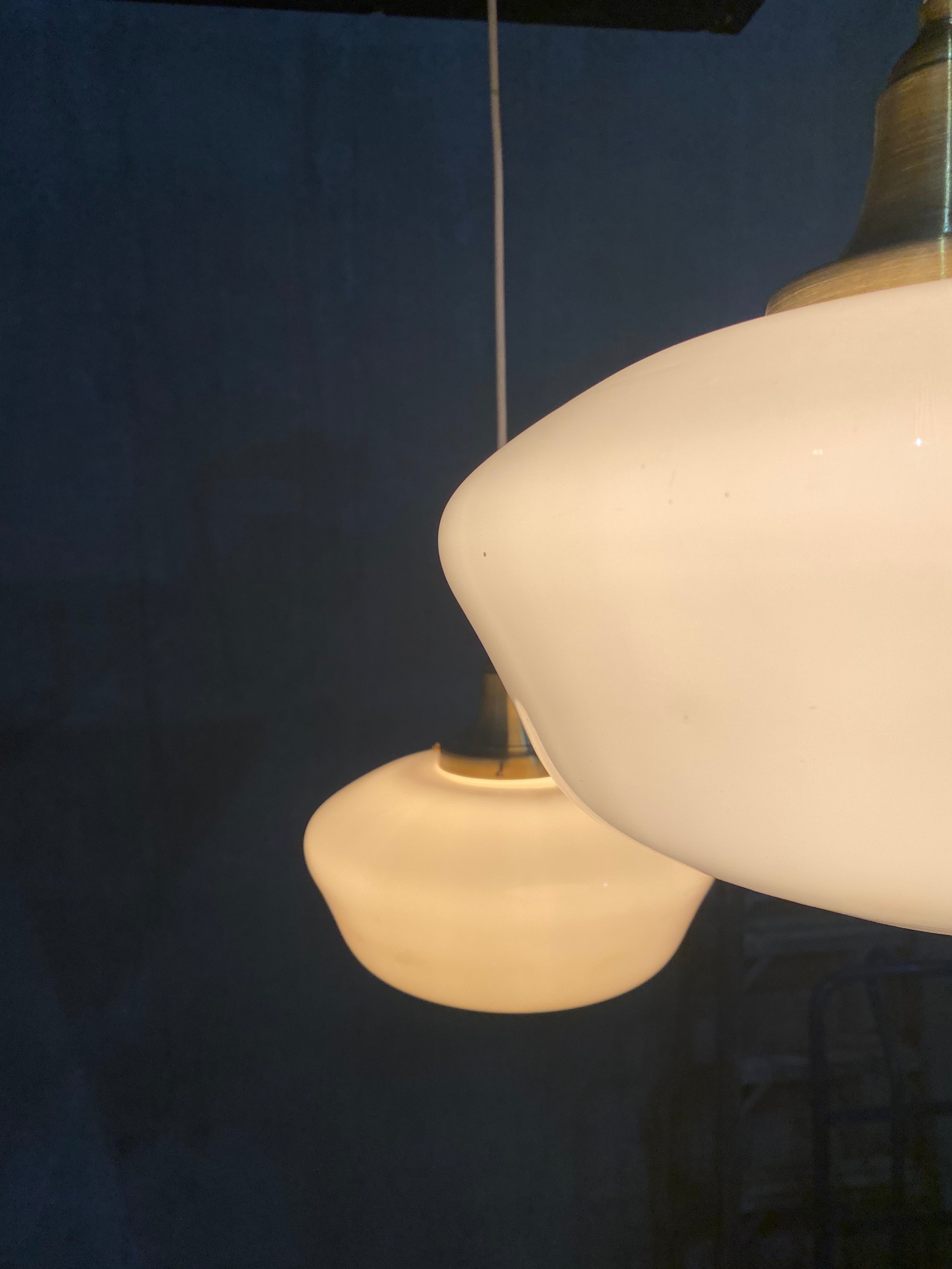 1920  school house milk glass pendant lights on brass fitter | Scott Landon Antiques and Interiors.