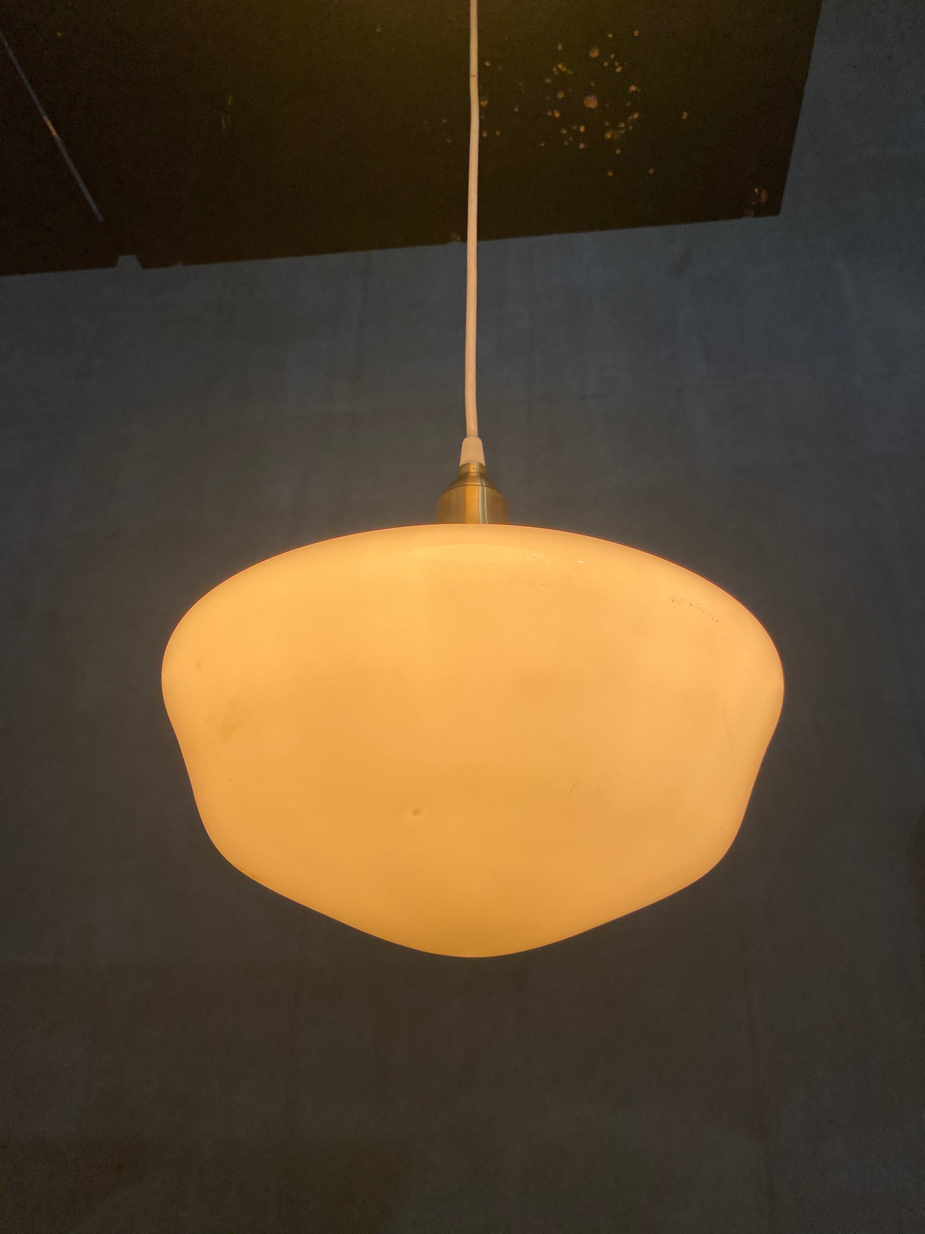 1920  school house milk glass pendant lights on brass fitter | Scott Landon Antiques and Interiors.