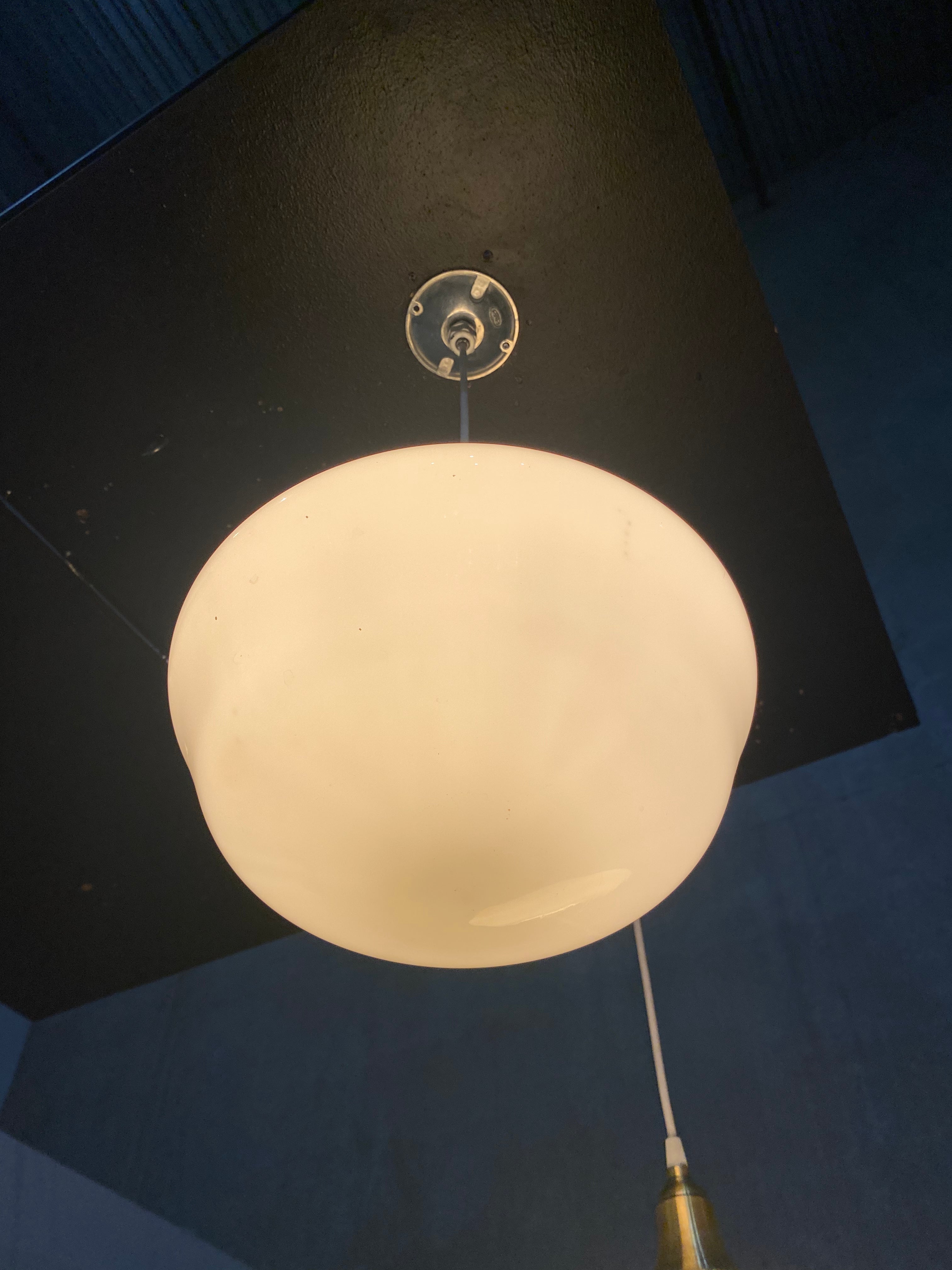 1920  school house milk glass pendant lights on brass fitter | Scott Landon Antiques and Interiors.